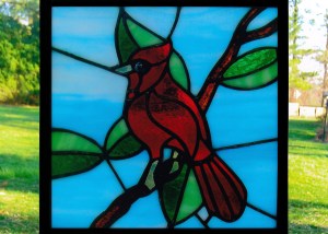 A Cardinal bird on a leafy branch that I made out of stained glass.